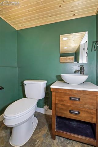 1914 Wooten Road Colorado Springs, CO 80915 - Photo 28 of 39 Bathroom with wooden ceiling, vanity, and stone finish flooring