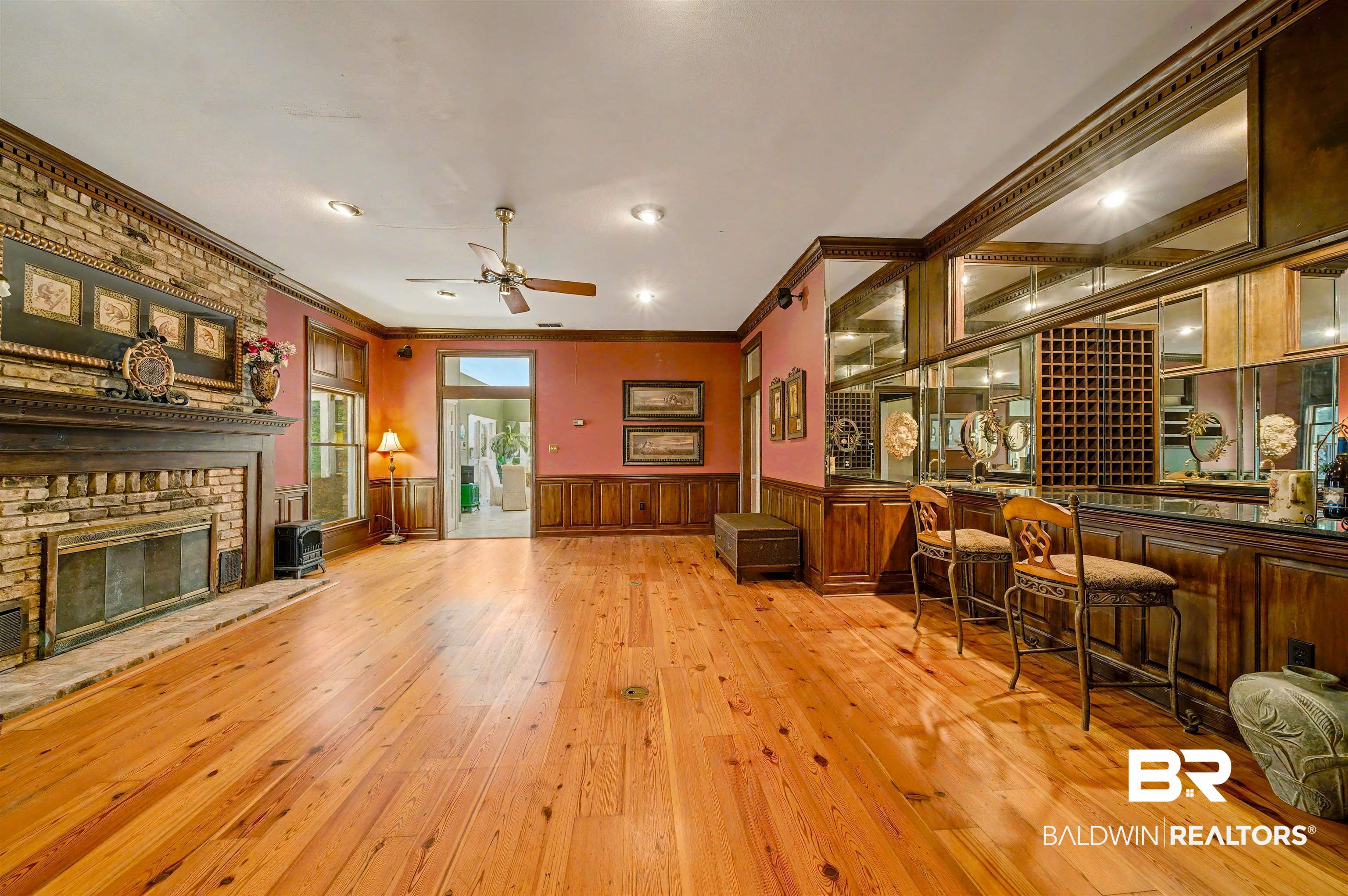 15810 County Road 73 Foley, AL 36535 - Photo 14 of 56 Living room with ornamental molding, a wainscoted wall, light wood-style floors, a brick fireplace, and ceiling fan