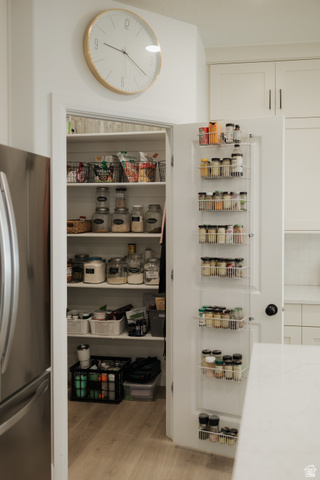 629 Spring Lily Drive St. George, UT 84790 - Photo 9 of 50 Walk-in pantry with multiple shelving units, door-mounted spice racks, and wood-finish flooring