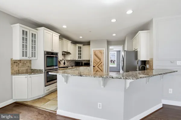 a kitchen with white cabinets and appliances