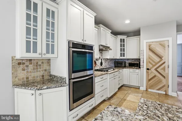 a kitchen with stainless steel appliances granite countertop a stove top oven and refrigerator