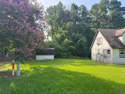 a view of a house with a yard and a tree