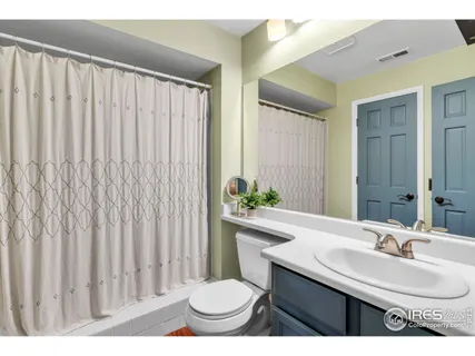 a bathroom with a sink a toilet and shower curtain