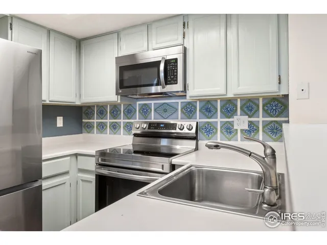 a kitchen with stainless steel appliances a stove a microwave and a sink