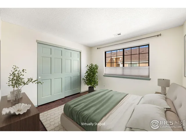a bedroom with a large bed and a potted plant
