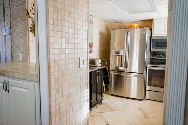 a metallic refrigerator freezer and a stove sitting inside of a kitchen