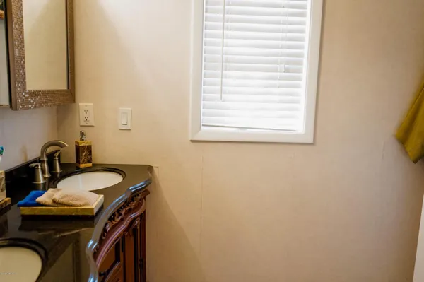a bathroom with a sink a mirror and a window
