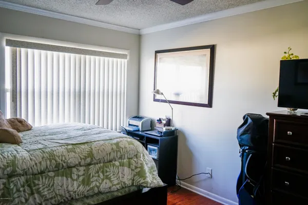 a bedroom with a bed and a flat tv screen on a table