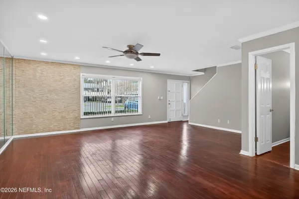 an empty room with wooden floor and windows