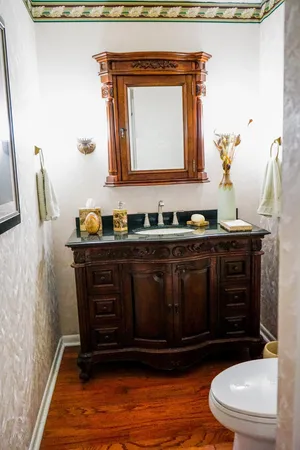 a bathroom with a toilet a sink and mirror