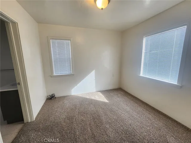 a view of an empty room with window and fireplace