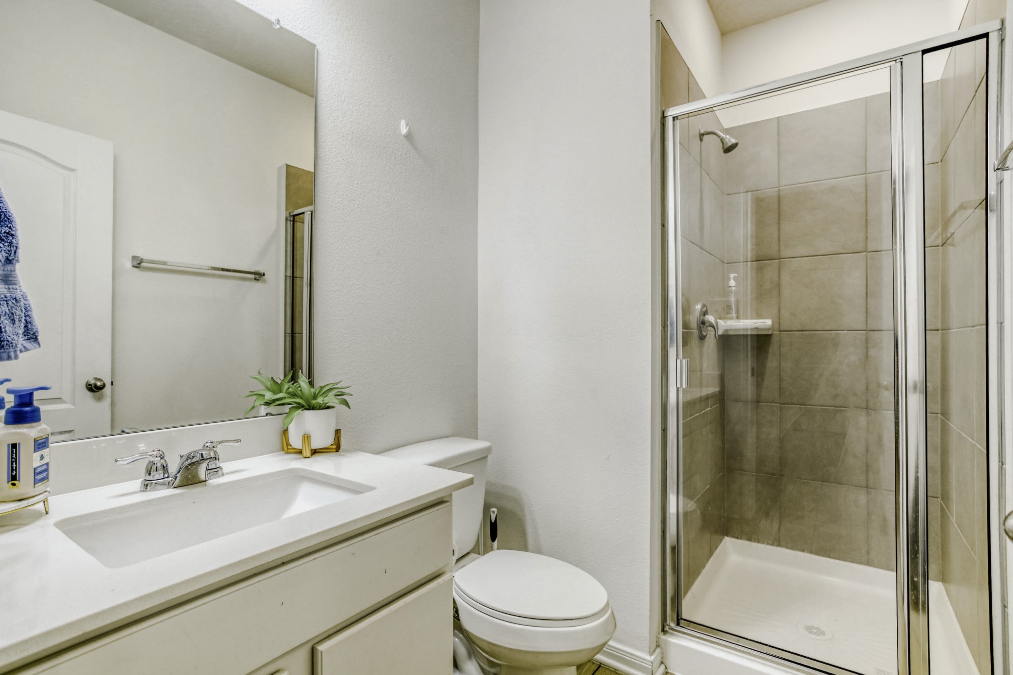 3331 Forest Chitto Dr Spring Spring, TX 77373 - Photo 13 of 29 This bathroom features a modern design with a glass-enclosed shower, tiled walls, and a sleek vanity with a single sink. It's bright and well-maintained, offering both functionality and style.