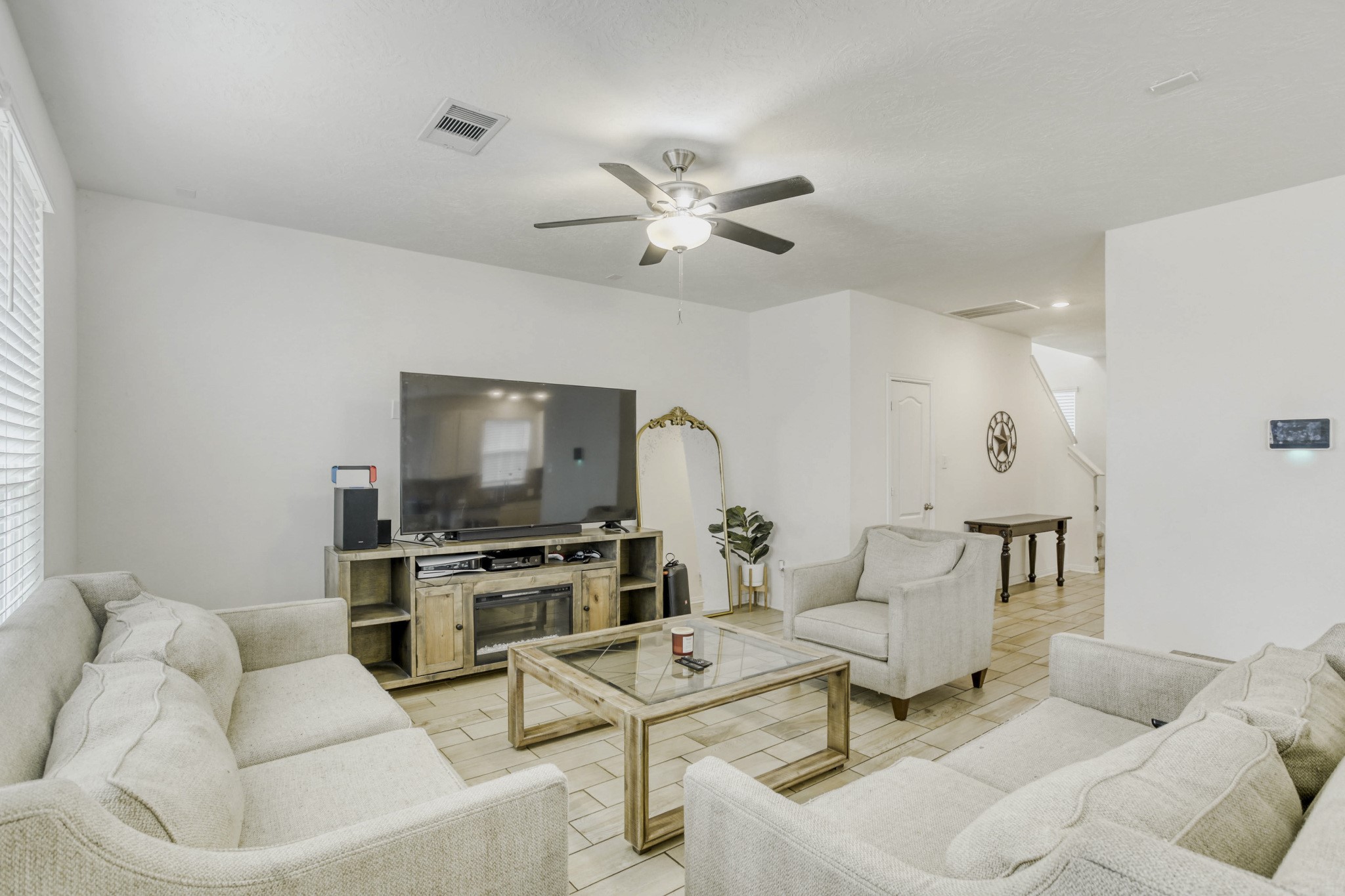3331 Forest Chitto Dr Spring Spring, TX 77373 - Photo 5 of 29 This inviting living room space is bright with natural light from the windows, and the open layout leads to a hallway with a staircase.
