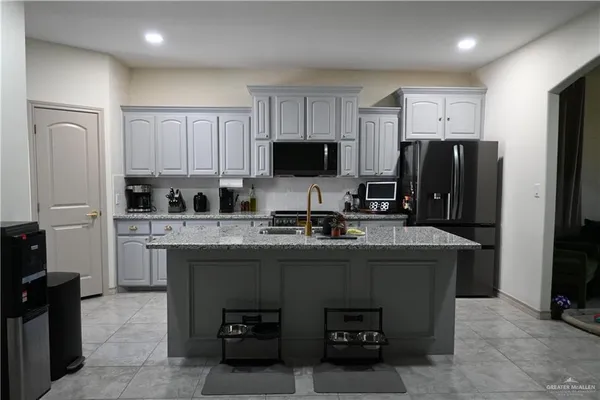 a kitchen with stainless steel appliances granite countertop a refrigerator stove top oven a sink and dishwasher