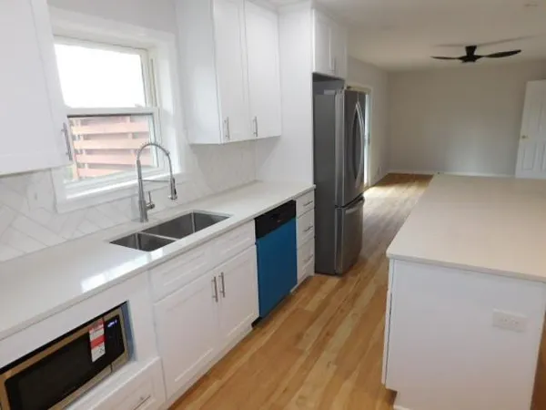 a kitchen with a sink a refrigerator and window