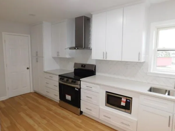 a kitchen with cabinets appliances and a window
