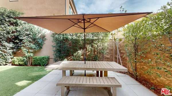a view of a patio with a table and chairs under an umbrella