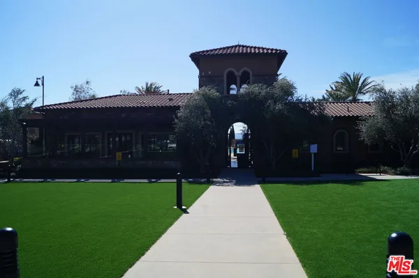 a palm tree sitting in front of a house with a yard