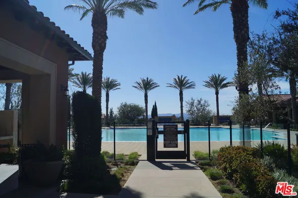 a view of a swimming pool with a table and chairs under an umbrella