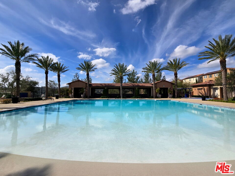 20607 West Chestnut Circle Porter Ranch, CA 91326 - Photo 51 of 52 a view of a swimming pool with a table and chairs under an umbrella