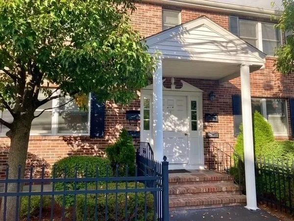 a front view of a house with a tree