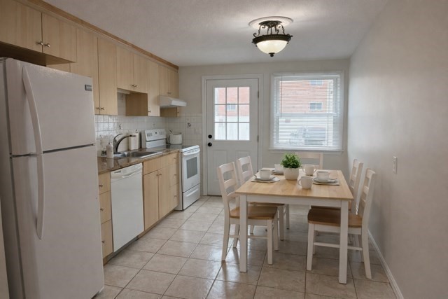 12 Cutter Street, Unit 1 Waltham, MA 02453 - Photo 3 of 9 a kitchen with a sink chairs and refrigerator