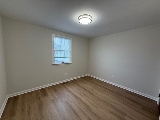 12 Cutter Street, Unit 1 Waltham, MA 02453 - Photo 6 of 9 an empty room with wooden floor and windows