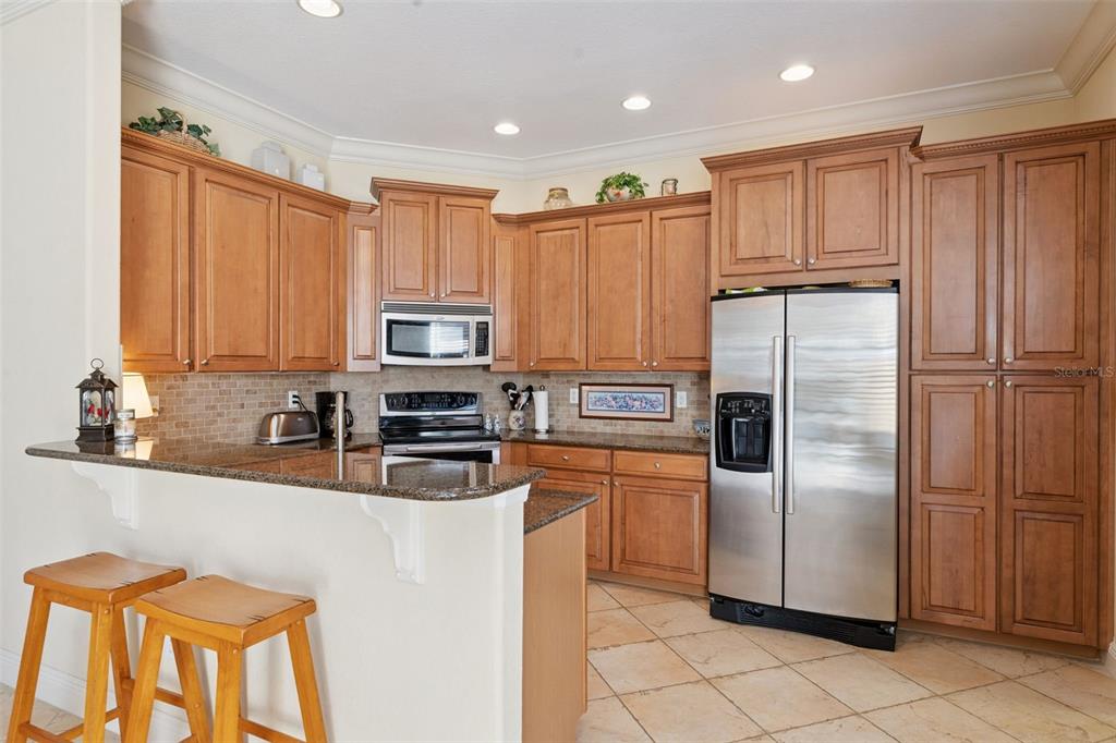 6552 Helmsley Circle Windermere, FL 34786 - Photo 13 of 53 a kitchen with granite countertop stainless steel appliances a refrigerator a stove top oven and cabinets