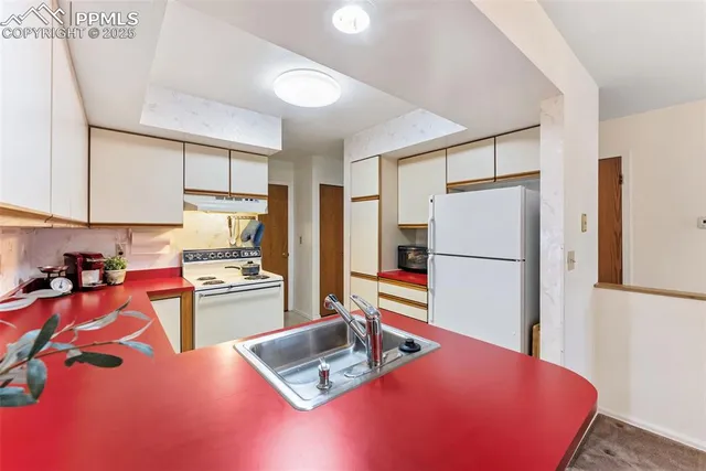 a kitchen with stainless steel appliances granite countertop a refrigerator sink stove and cabinets