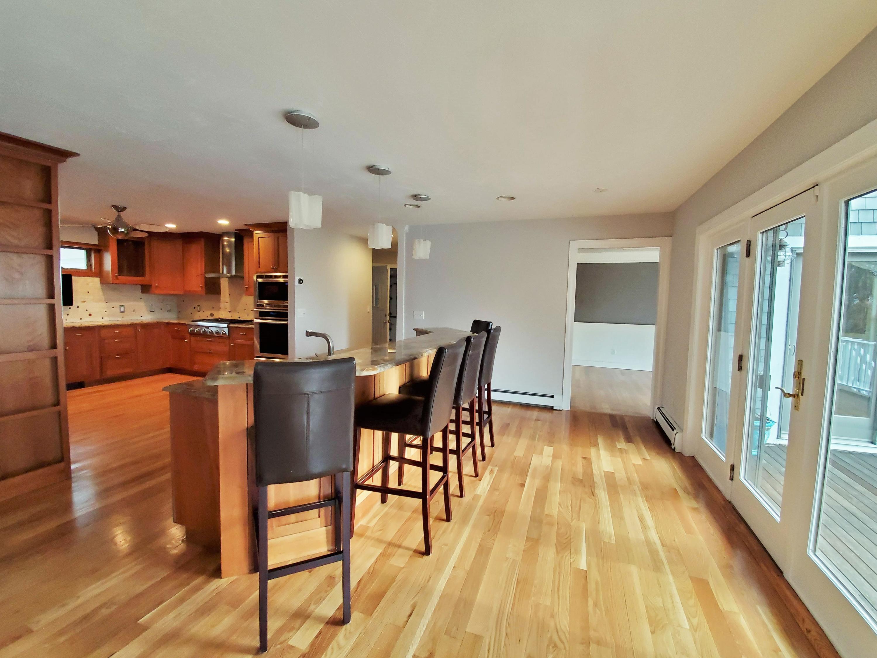 50 Major Doane Road Wellfleet, MA 02667 - Photo 16 of 91 a kitchen with stainless steel appliances a dining table chairs and granite counter tops