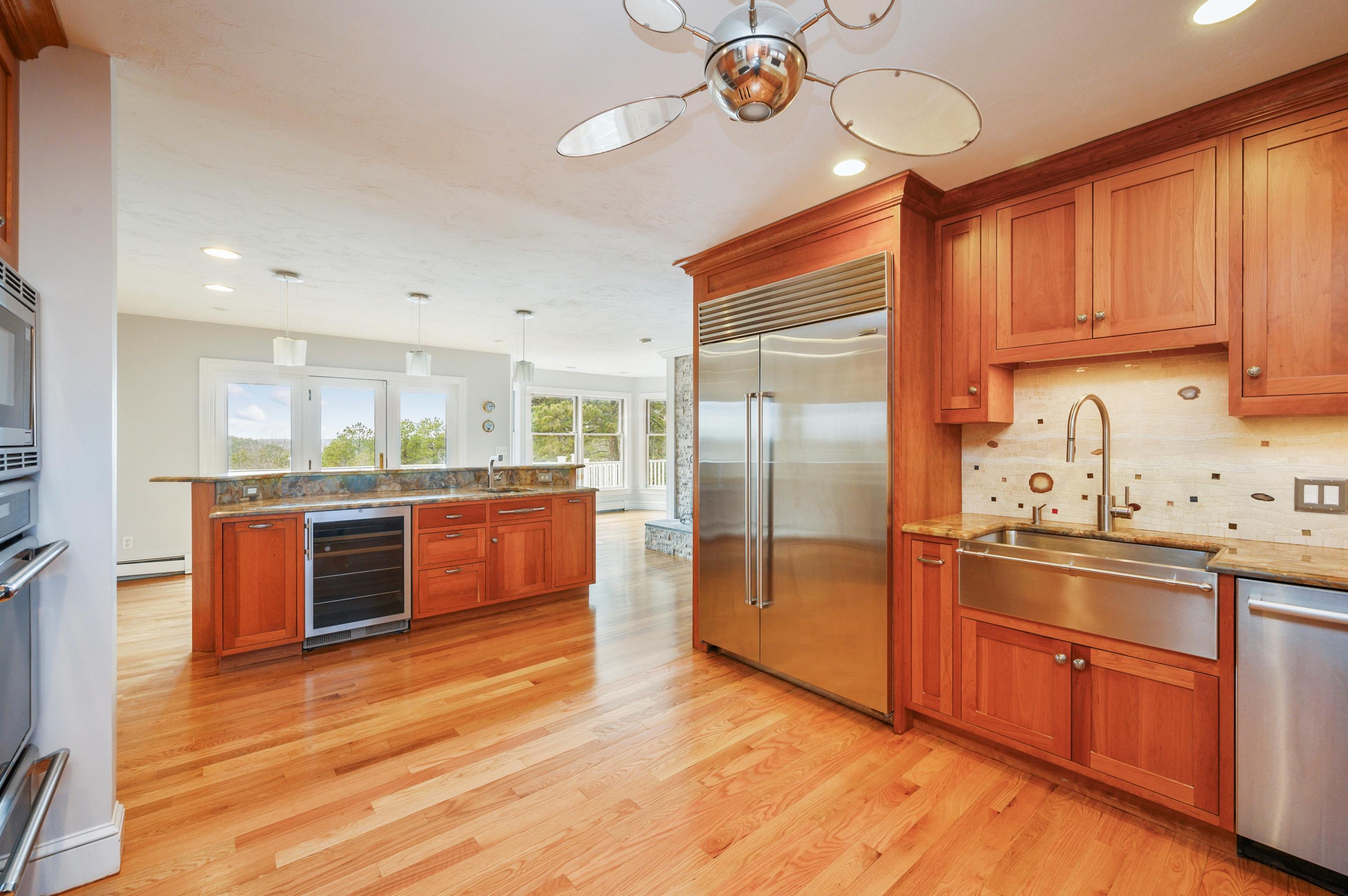 50 Major Doane Road Wellfleet, MA 02667 - Photo 19 of 91 a kitchen with stainless steel appliances granite countertop a stove a sink dishwasher and a refrigerator with wooden floor