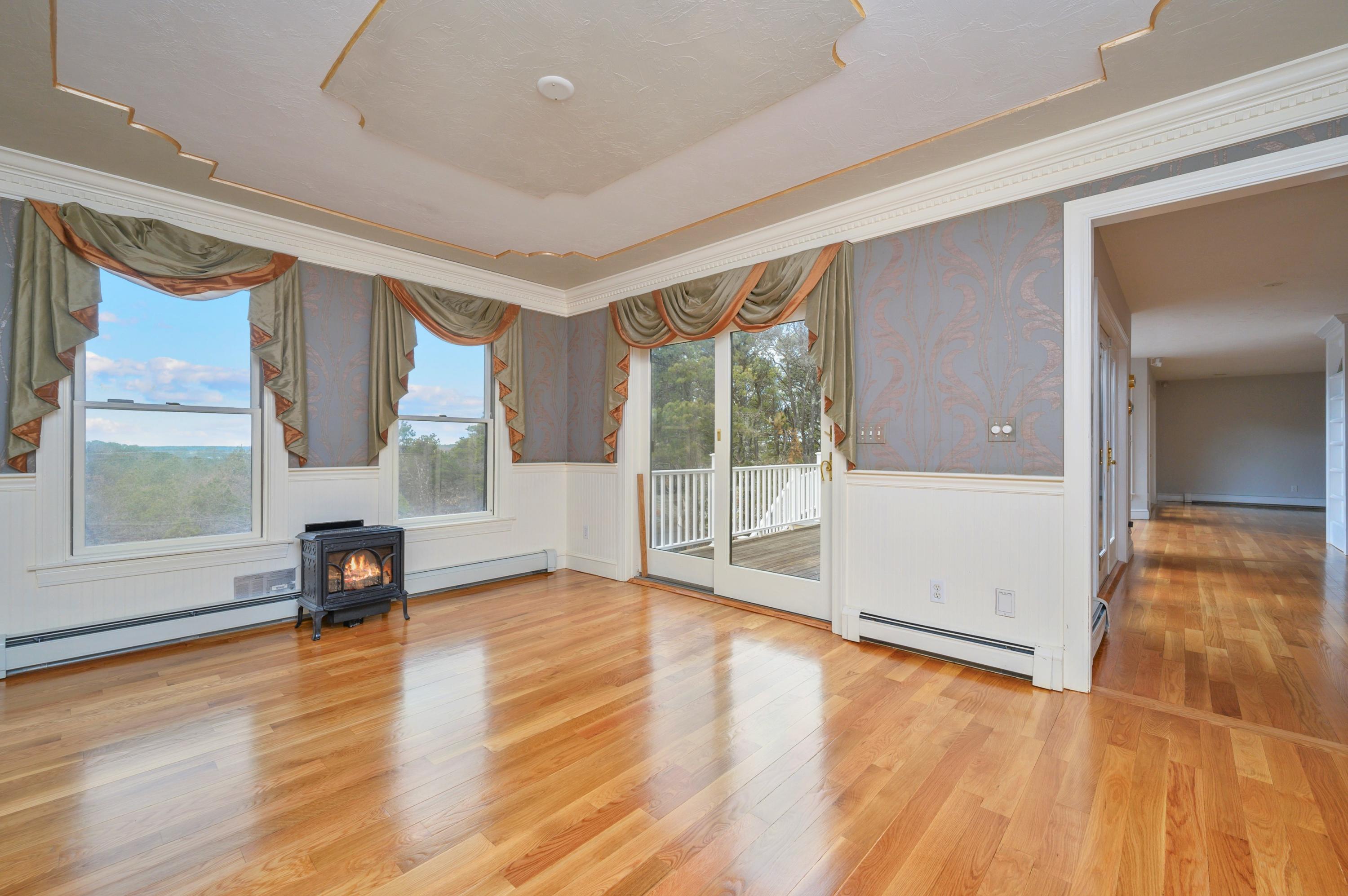 50 Major Doane Road Wellfleet, MA 02667 - Photo 22 of 91 an empty room with wooden floor and windows