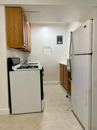 a utility room with wooden floor and cabinets