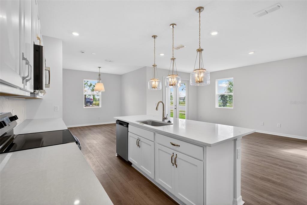 5777 Haystack Drive St. Cloud, FL 34771 - Photo 12 of 37 a kitchen with kitchen island granite countertop a sink a counter space appliances and cabinets