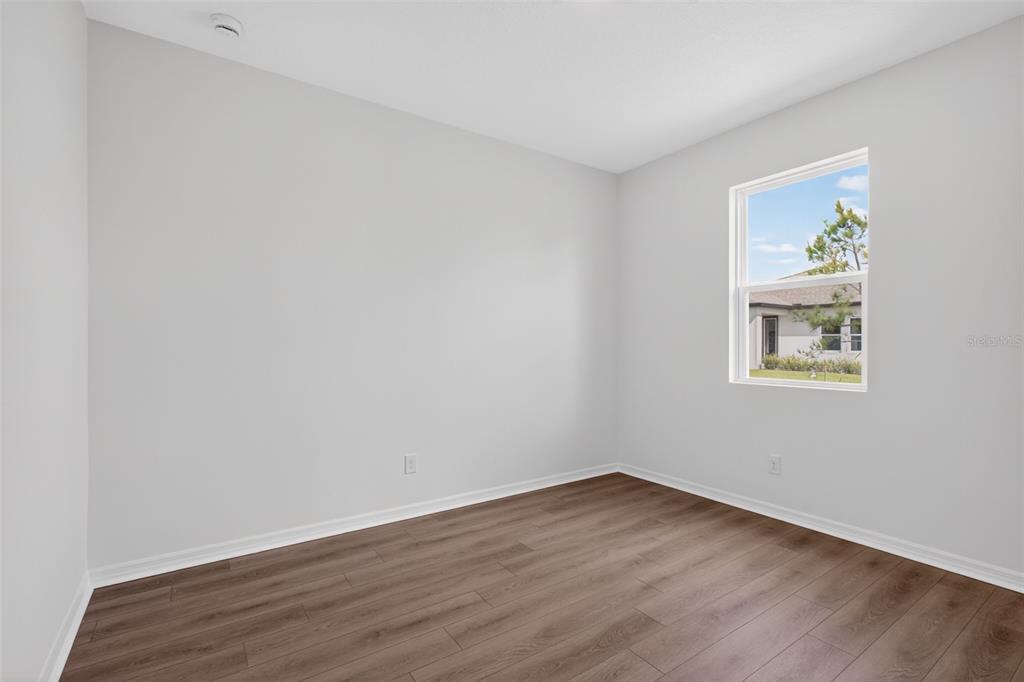 5777 Haystack Drive St. Cloud, FL 34771 - Photo 17 of 37 a view of an empty room with wooden floor and a window