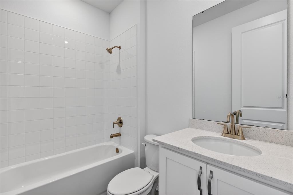 5777 Haystack Drive St. Cloud, FL 34771 - Photo 19 of 37 a bathroom with a granite countertop sink toilet and shower