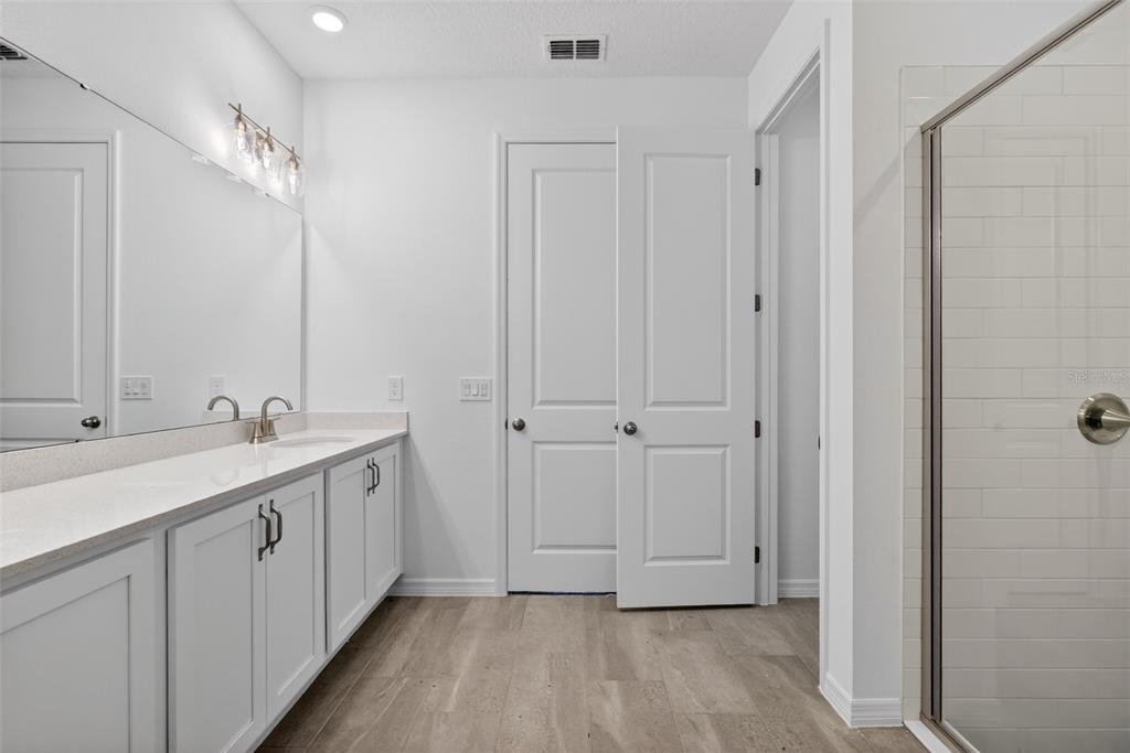 5777 Haystack Drive St. Cloud, FL 34771 - Photo 25 of 37 a bathroom with a double vanity sink and mirror