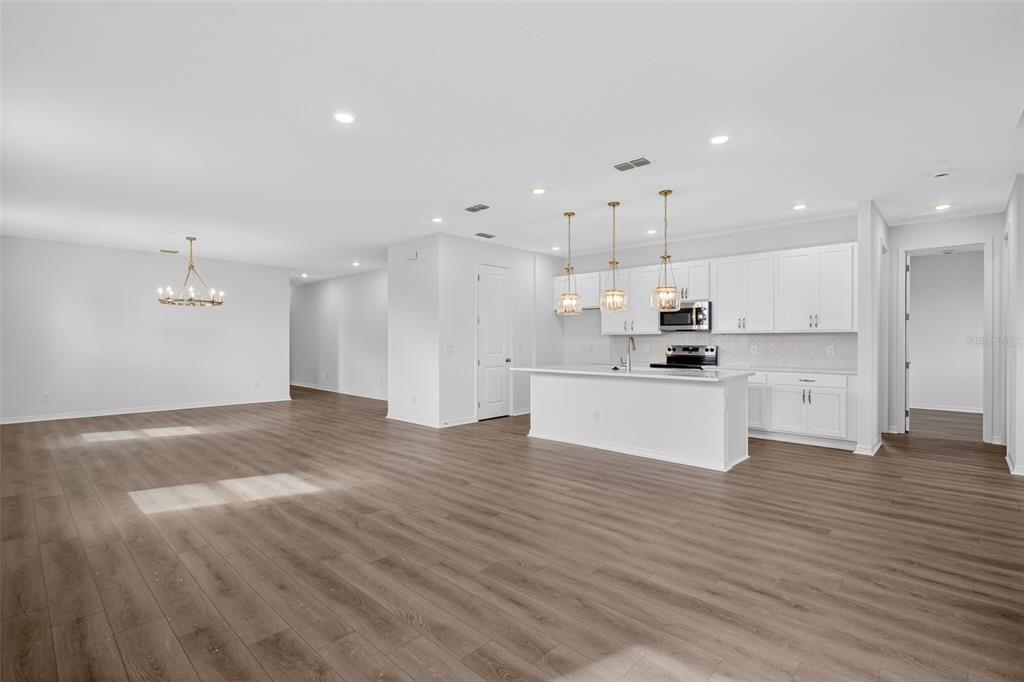 5777 Haystack Drive St. Cloud, FL 34771 - Photo 9 of 37 a large kitchen with stainless steel appliances kitchen island a large counter top and a stove top oven