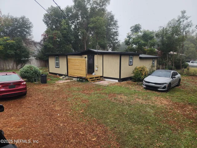 a backyard of a house with fire pit and couches