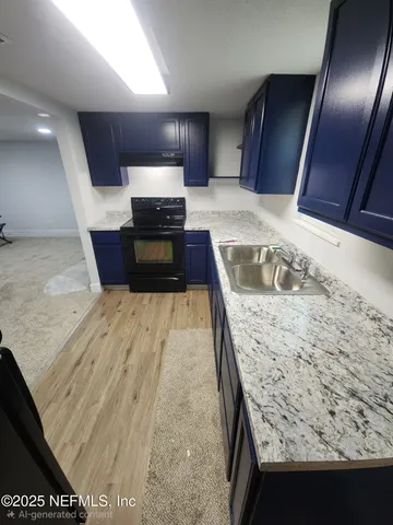 a kitchen with granite countertop sink and refrigerator