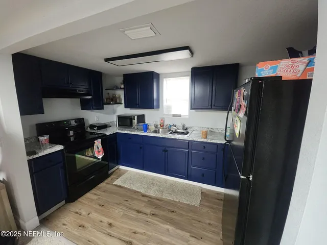 a kitchen with stainless steel appliances granite countertop a refrigerator stove and sink