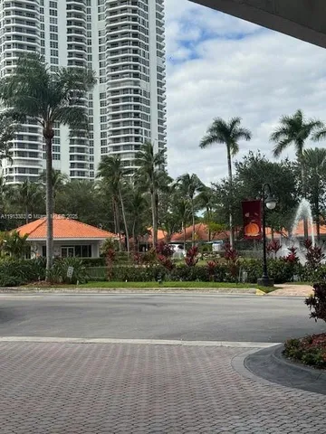 a street with a building and palm trees