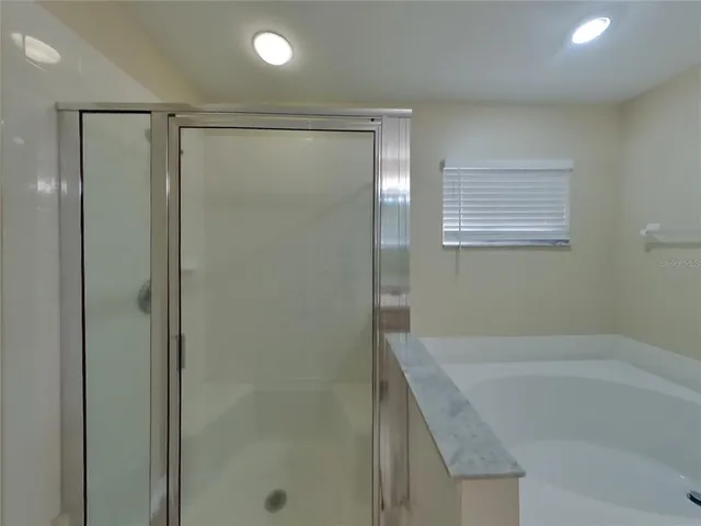 a bathroom with a granite countertop bathtub shower and sink
