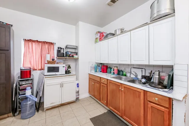 a kitchen with cabinets a sink and white appliances