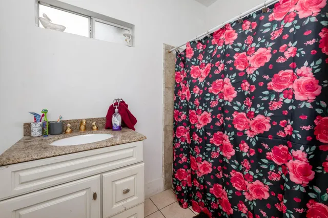 a utility room with a sink mirror and vanity