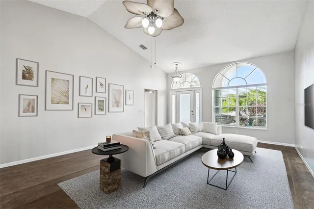 a living room with furniture a large window and a dining table