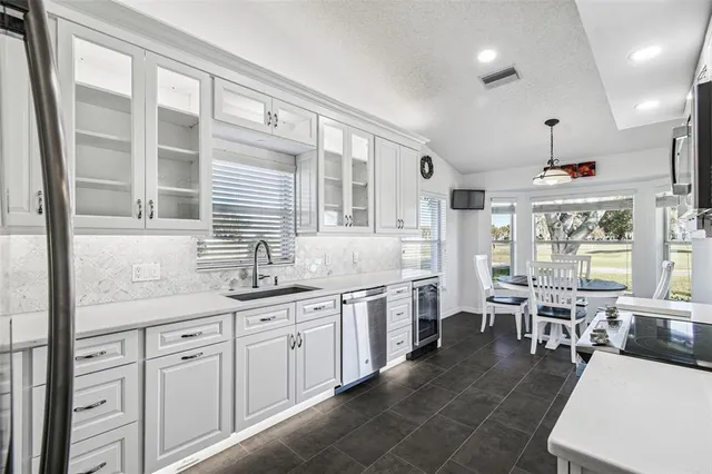 a large white kitchen with a large window