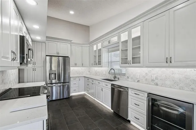 a kitchen with stainless steel appliances granite countertop a refrigerator and a sink