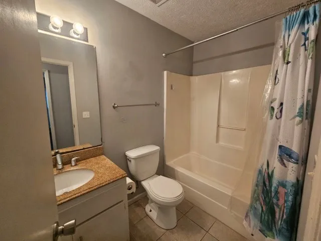 a bathroom with a granite countertop sink toilet a mirror and shower