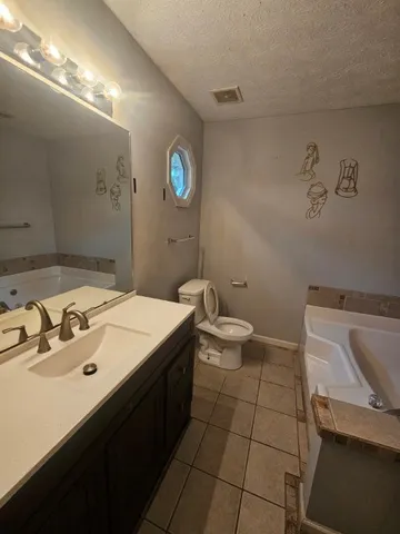 a spacious bathroom with a toilet a sink and a mirror